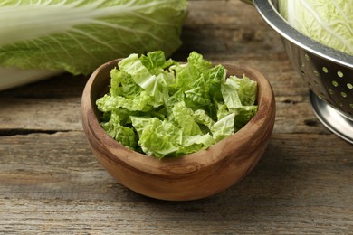 Photo of Cut fresh Chinese cabbage on wooden table, closeup