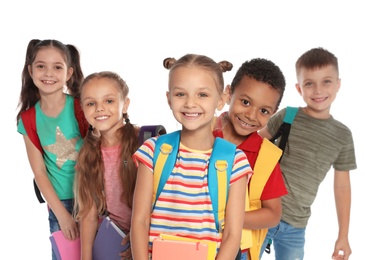 Group of little children with backpacks and school supplies on white background