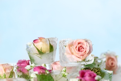 Photo of Ice cubes with flowers on color background, closeup. Space for text