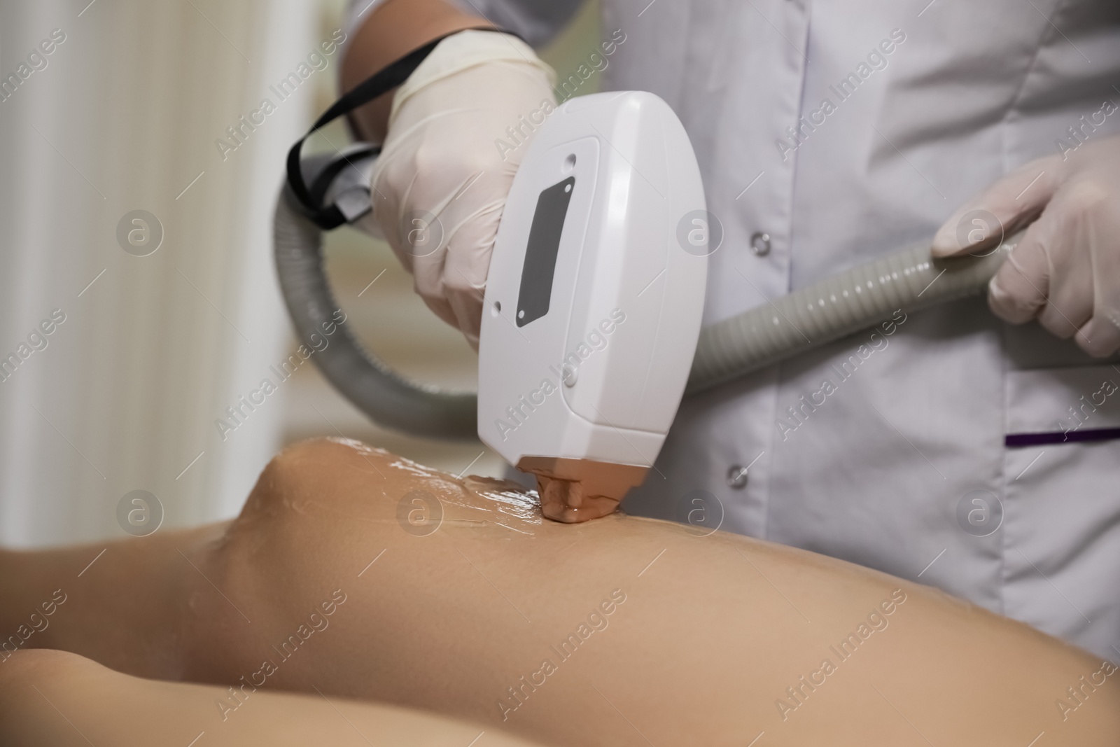 Photo of Woman undergoing laser epilation procedure in beauty salon, closeup