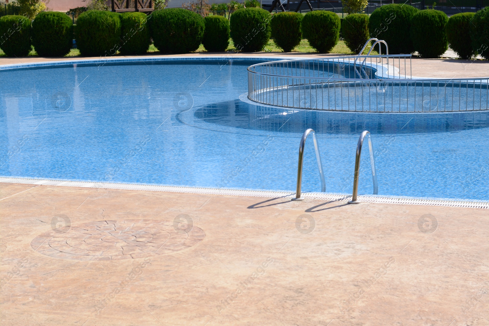 Photo of Clean swimming pool with metal ladder on sunny day outdoors