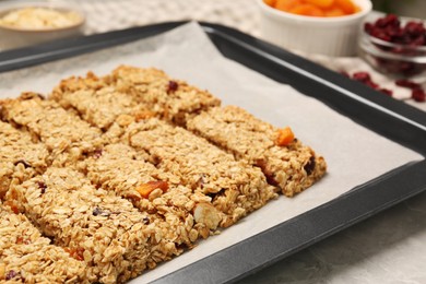 Photo of Many tasty granola bars on baking tray, closeup