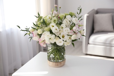 Photo of Bouquet of beautiful flowers on table in living room. Interior design