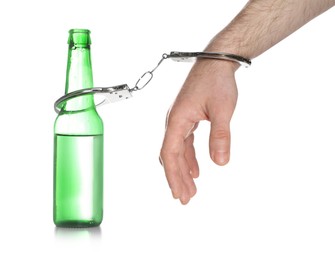 Photo of Man in handcuffs with bottle of beer on white background, closeup. Alcohol addiction