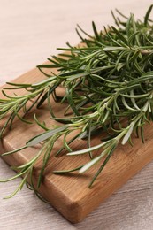Photo of Sprigs of fresh rosemary on white wooden table, closeup