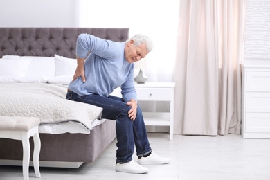 Senior man suffering from back pain at home