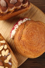 Photo of Crunchy round croissants on wooden table, top view. Tasty puff pastry