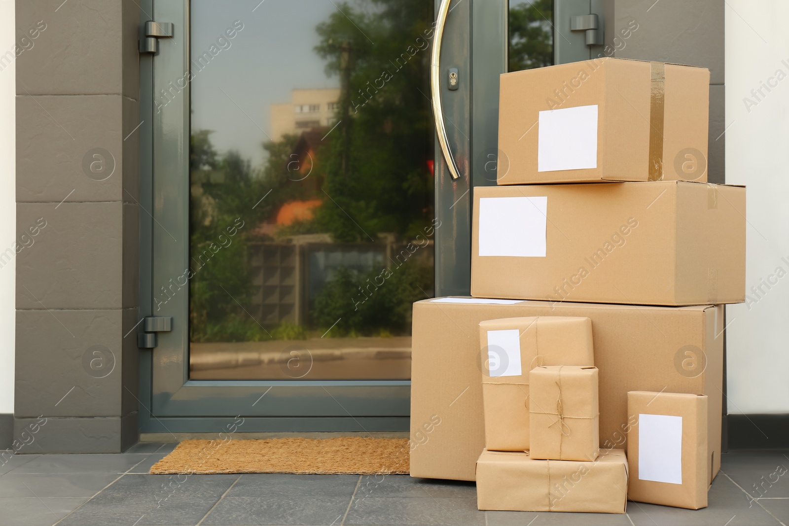 Photo of Cardboard boxes near door. Parcel delivery service