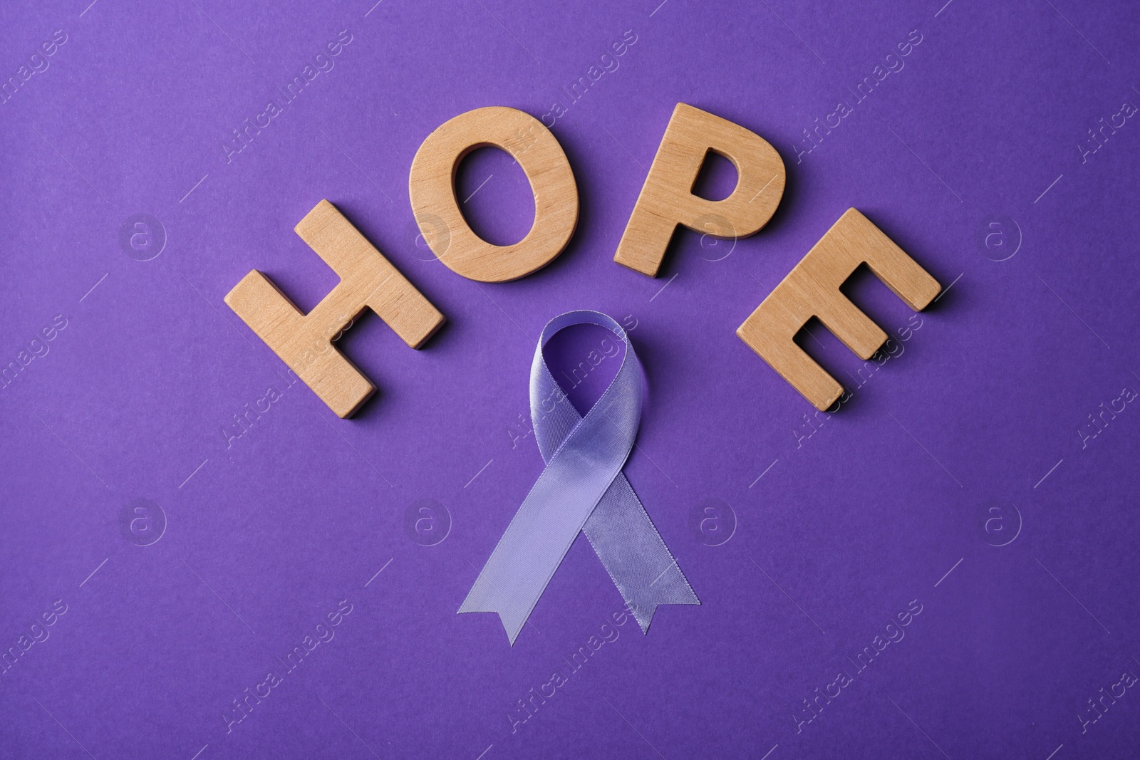 Photo of Flat lay composition with purple ribbon and word HOPE on violet background. Domestic violence awareness