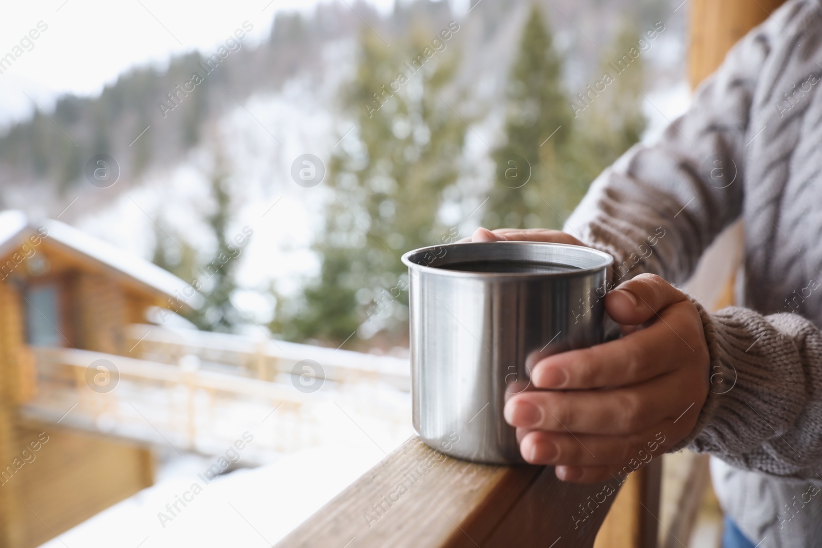 Photo of Woman with cup of tasty coffee outdoors on winter morning, closeup