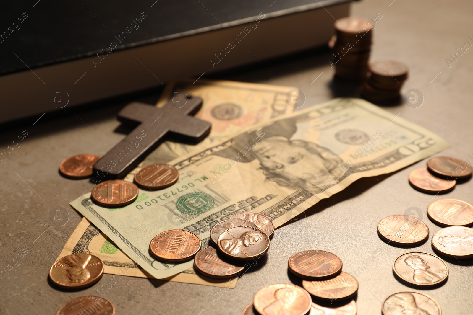 Photo of Donate and give concept. Coins, Bible, cross and dollar banknotes on grey table, selective focus