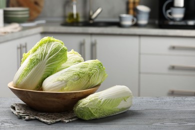 Fresh Chinese cabbages on grey wooden table, space for text