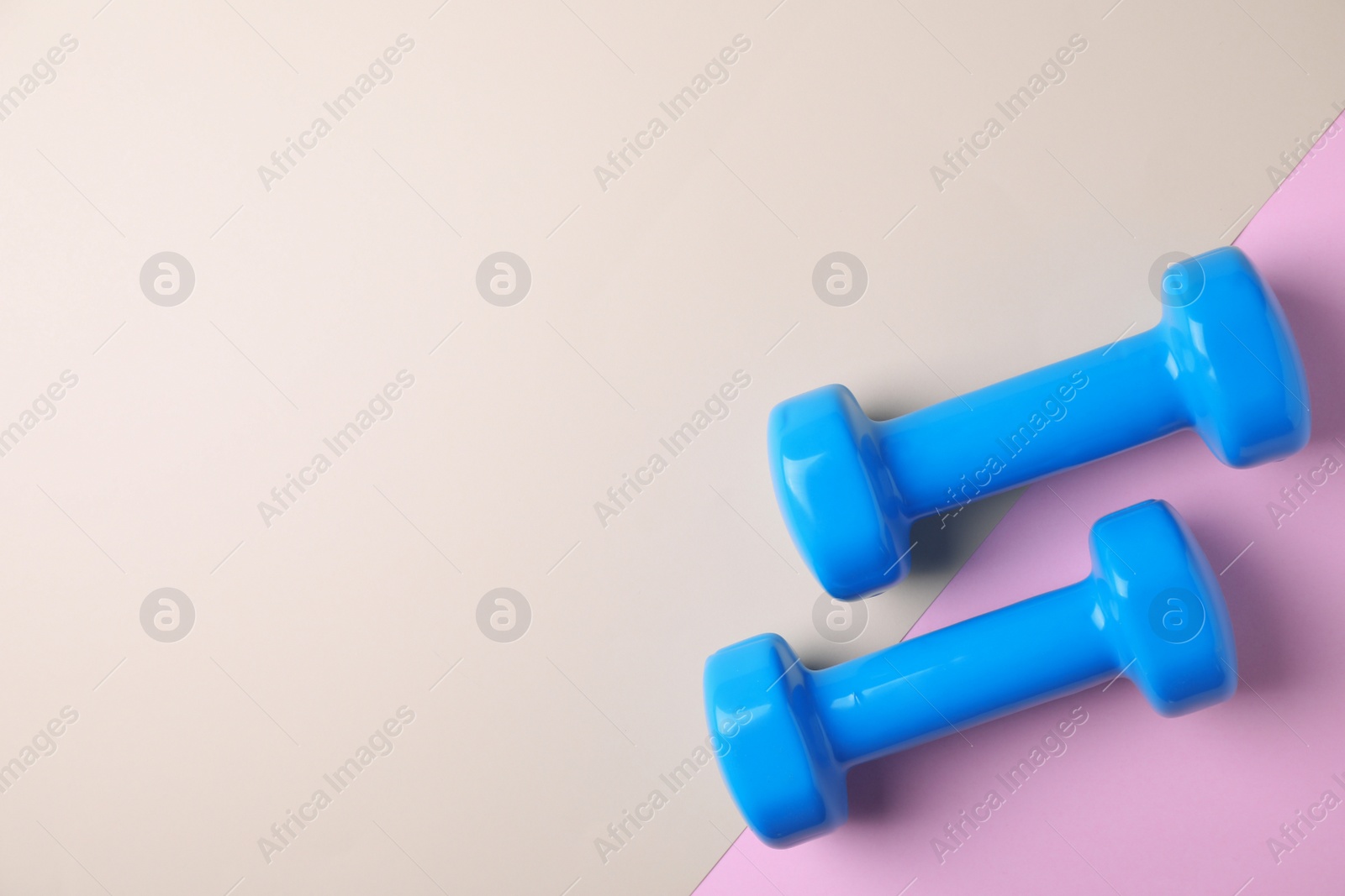 Photo of Vinyl dumbbells and space for text on color background, flat lay