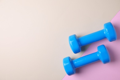 Photo of Vinyl dumbbells and space for text on color background, flat lay