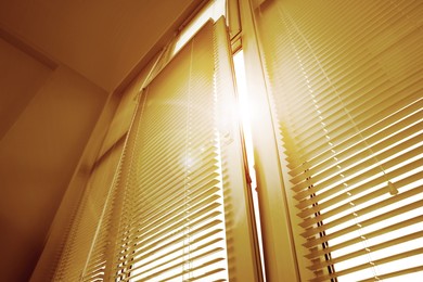 Image of Stylish window with horizontal blinds in room, low angle view