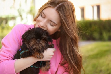Young woman with adorable Brussels Griffon dog outdoors