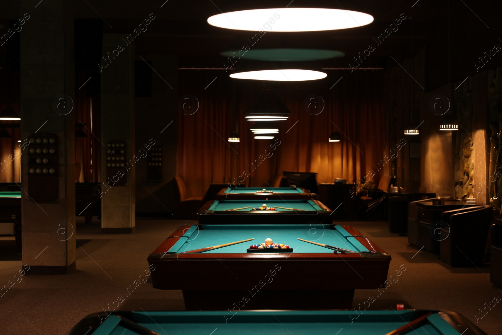 Photo of Billiard tables with balls and cues in club