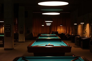 Photo of Billiard tables with balls and cues in club