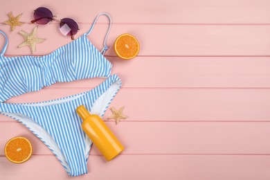 Flat lay composition with beach objects on pink wooden background, space for text