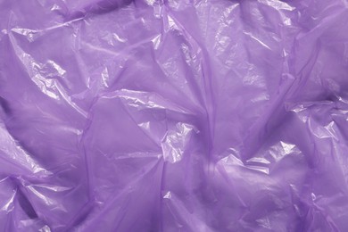 Crumpled purple plastic bag as background, top view