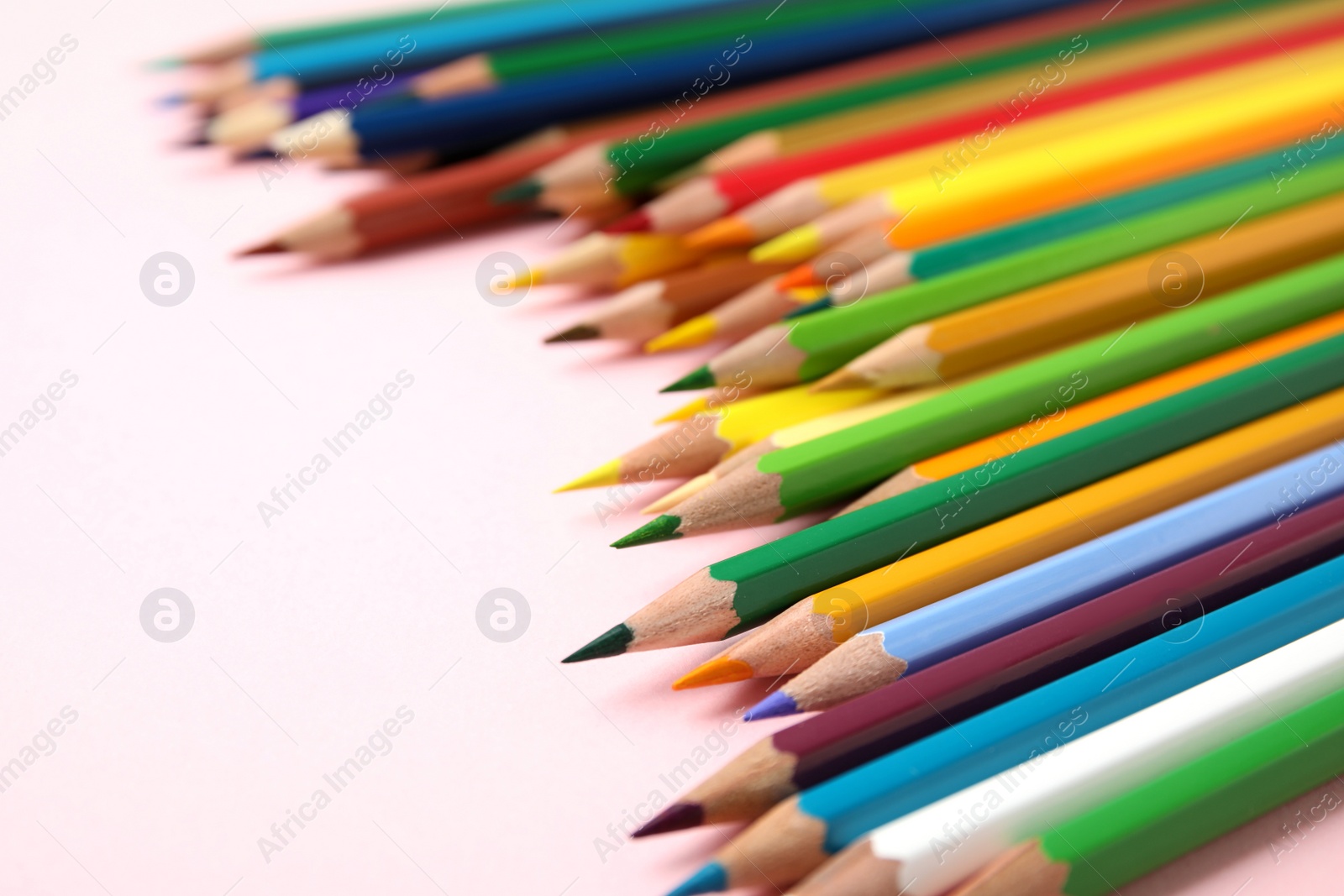 Photo of Composition with color pencils on pink background