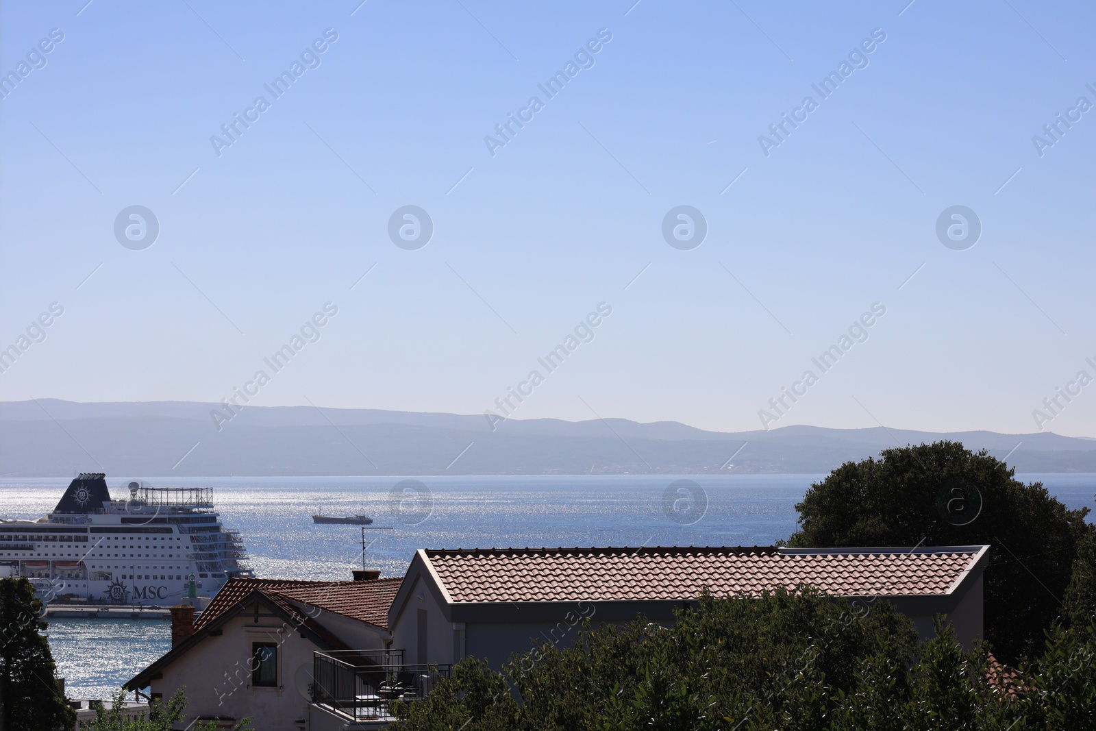 Photo of Beautiful view of buildings and calm sea with cruise under blue sky