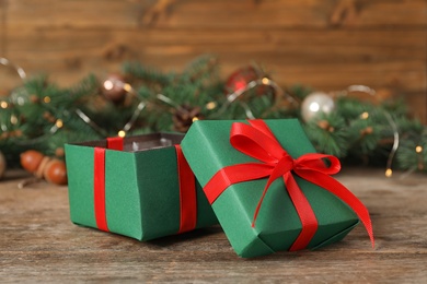 Green Christmas gift boxes with red bow on wooden table