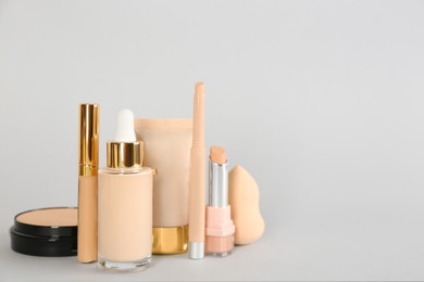 Photo of Foundation makeup products on light background, space for text. Decorative cosmetics