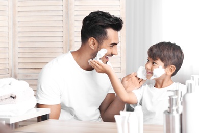 Father and son having fun while shaving in bathroom