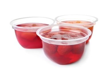 Photo of Tasty jelly desserts in plastic cups on white background