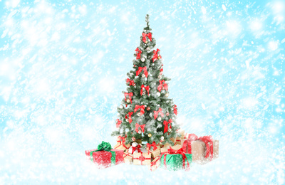 Image of Beautiful Christmas tree with gifts under snowfall