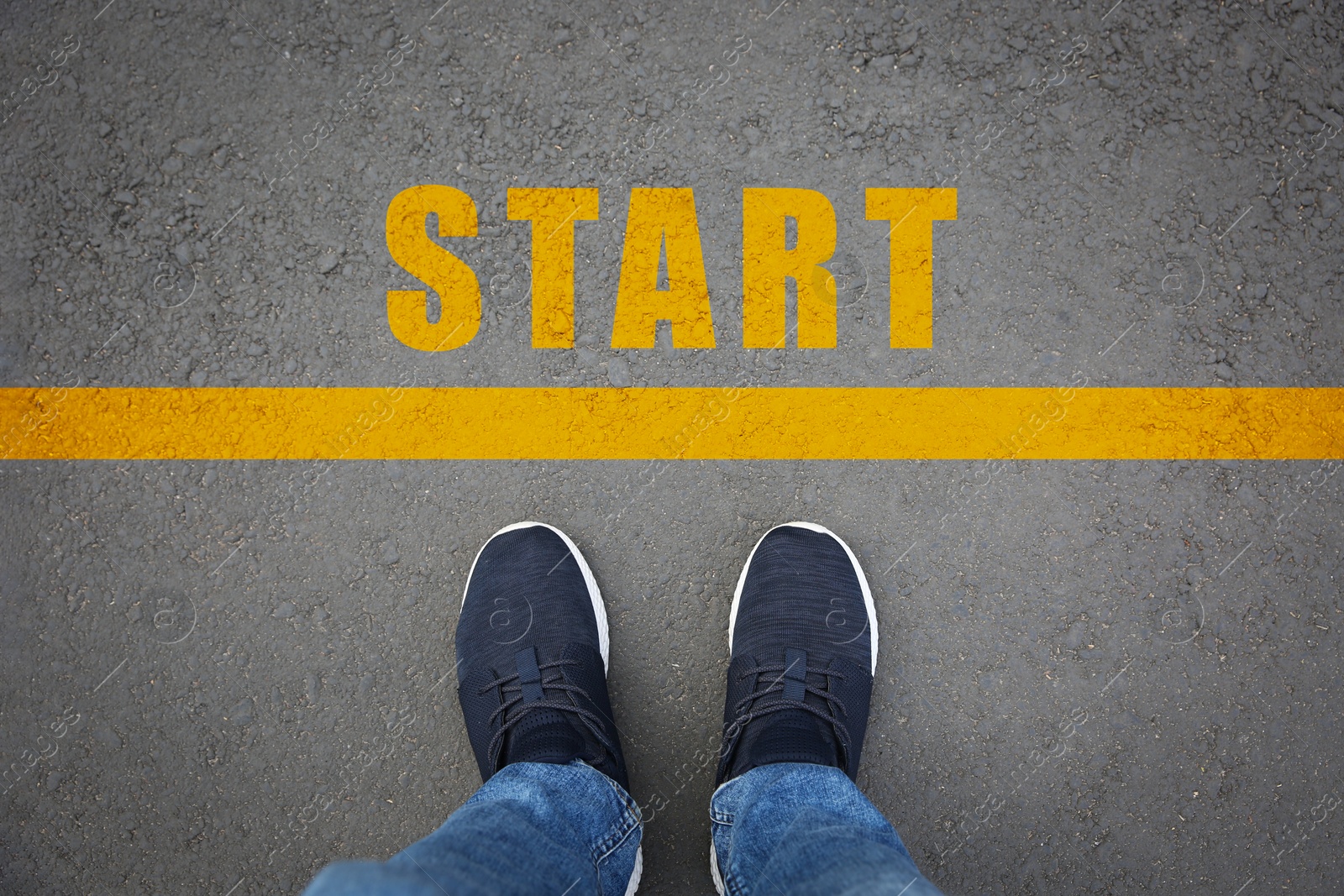 Image of New beginnings. Man standing near word Start on asphalt, top view