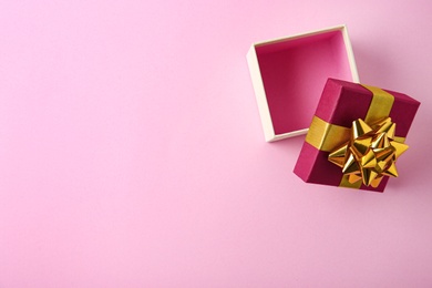 Photo of Open empty gift box on pink background, flat lay. Space for text