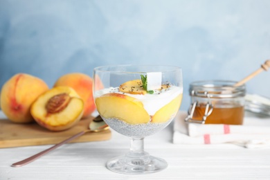 Tasty peach dessert with yogurt and chia seeds served on white wooden table