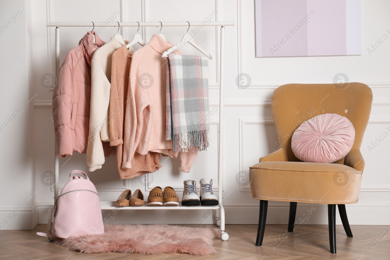 Photo of Rack with stylish warm clothes, shoes and accessories in modern dressing room