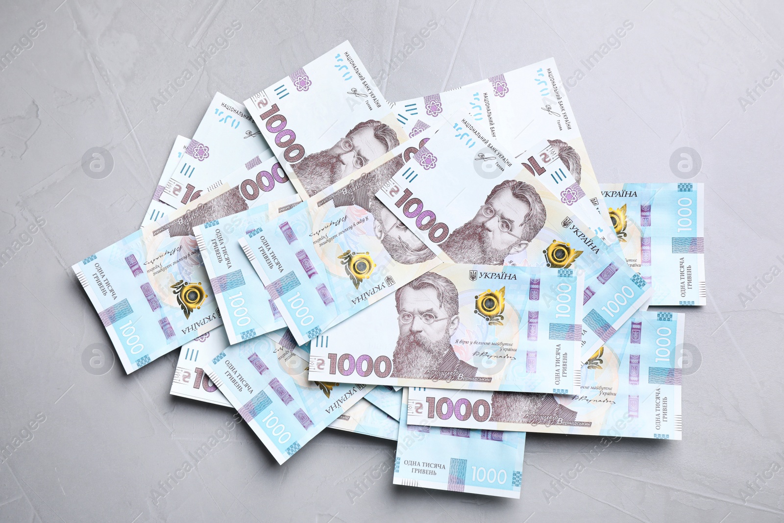 Photo of Ukrainian money on grey background, flat lay