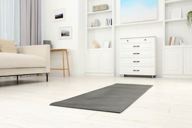 Photo of Grey yoga mat on floor in room