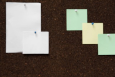 Blurred view of dark corkboard with pinned notes