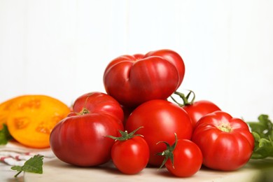 Photo of Pile of different ripe tomatoes on table