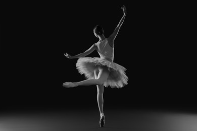 Photo of Young ballerina practicing dance moves. Black and white effect