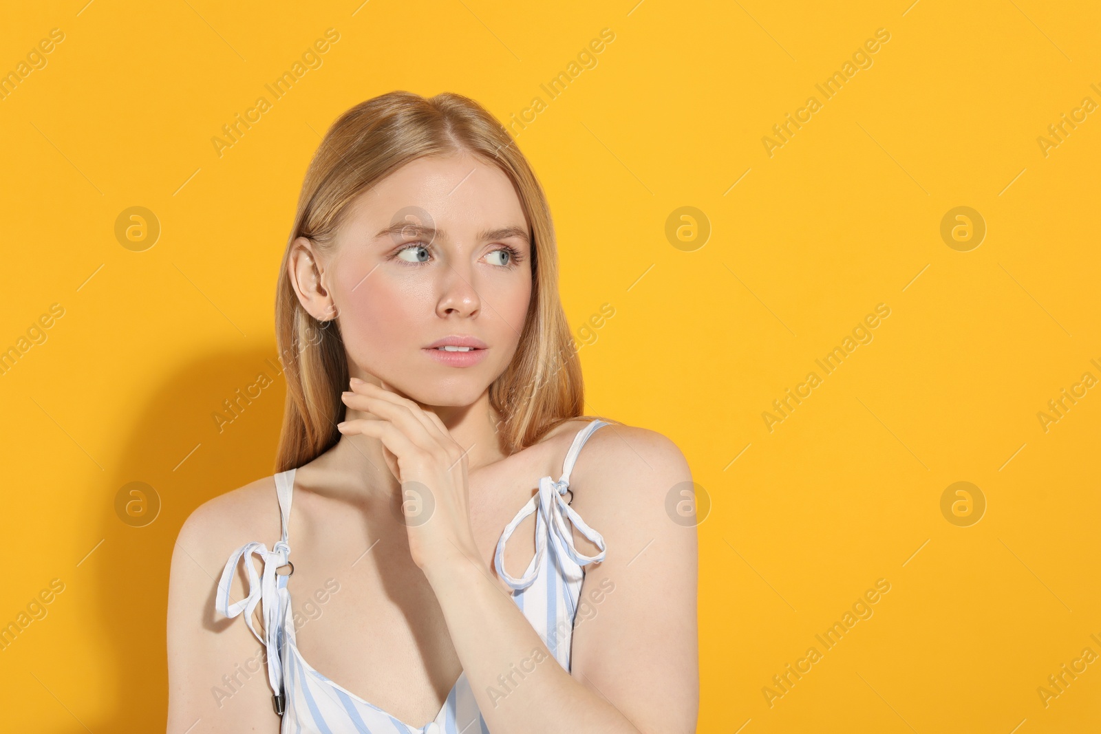 Photo of Beautiful young woman posing on orange background, space for text