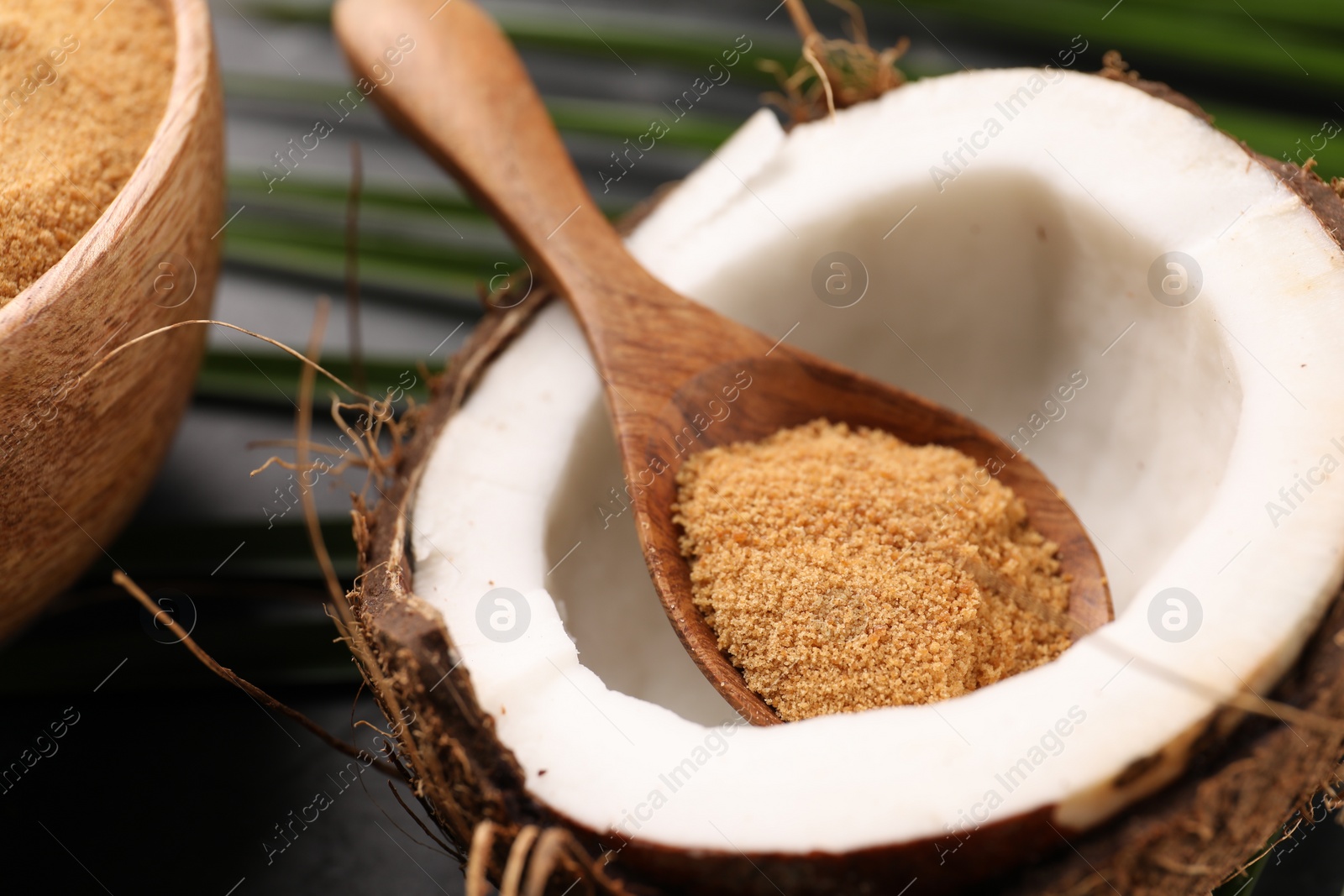 Photo of Spoon with coconut sugar and fruit on table, closeup