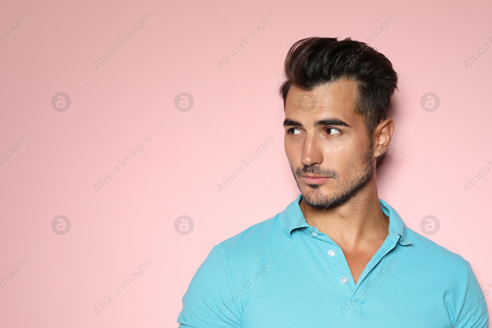 Photo of Young man with trendy hairstyle posing on color background