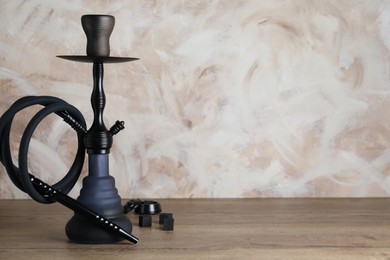 Photo of Traditional hookah on wooden table. Space for text