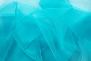 Photo of Beautiful turquoise tulle fabric as background, closeup