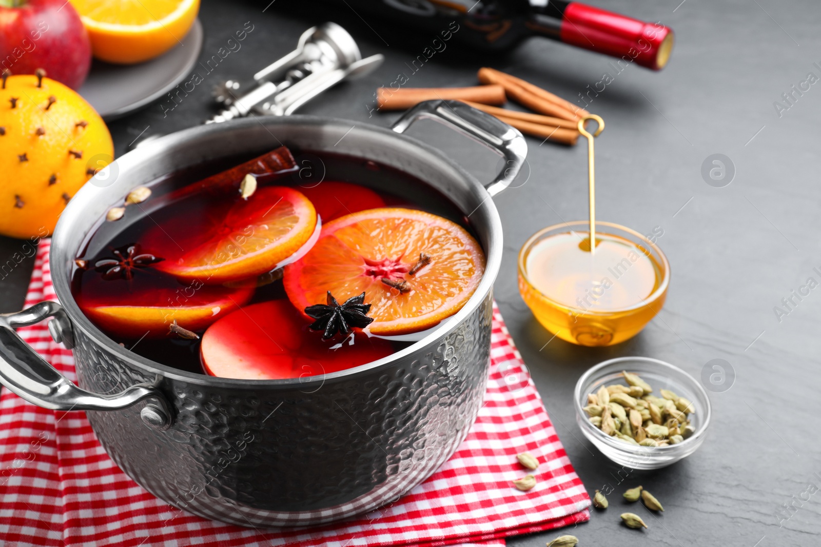 Photo of Delicious mulled wine and ingredients on grey table