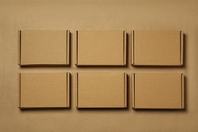 Many closed cardboard boxes on light brown background, flat lay