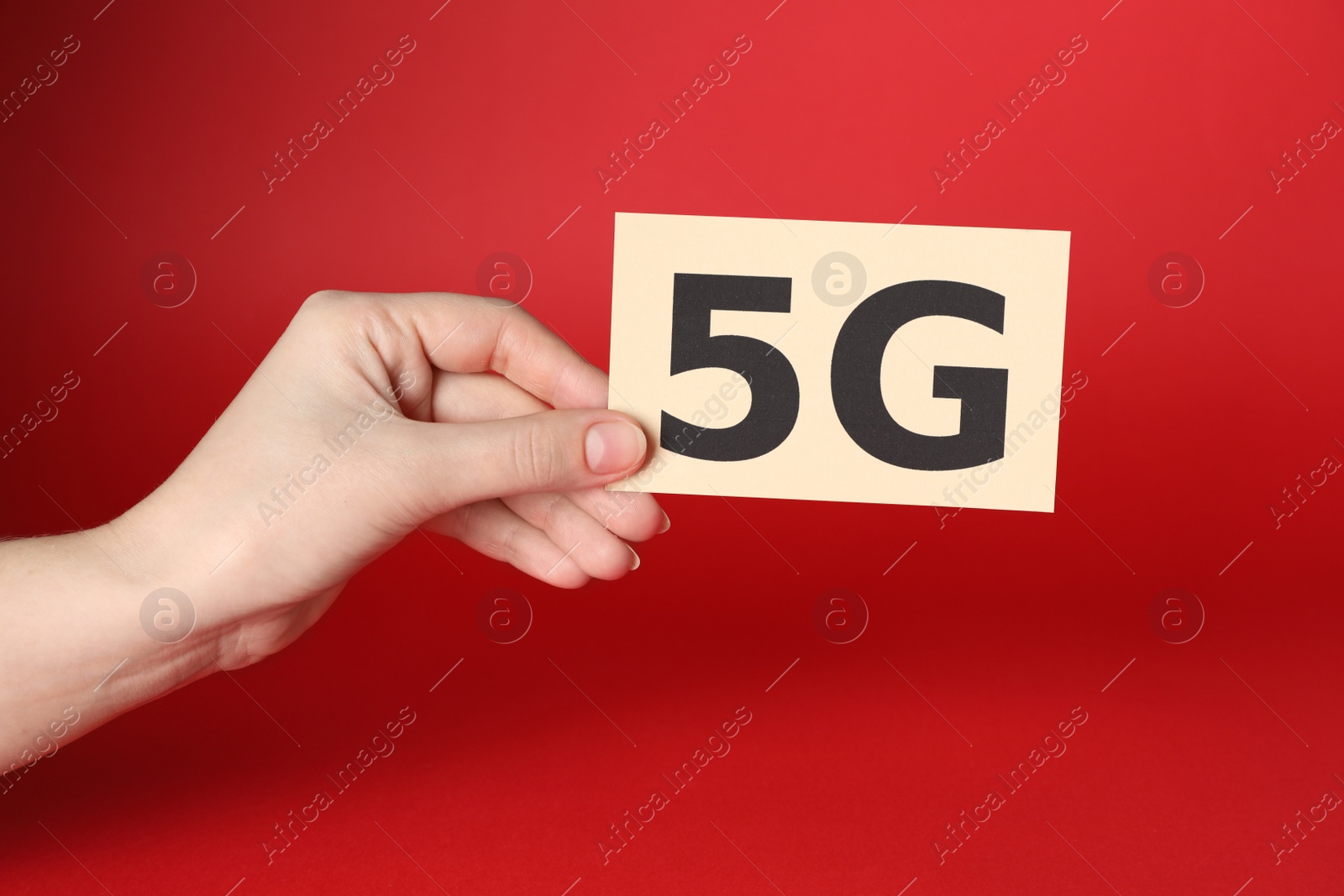 Photo of Internet concept. Woman holding 5G card on red background, closeup