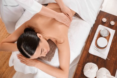 Photo of Young woman having professional massage in spa salon, above view