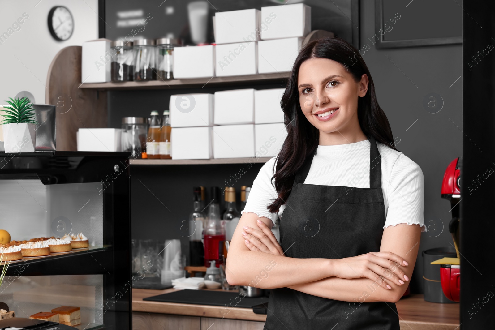 Photo of Business owner near showcases with desserts in her cafe